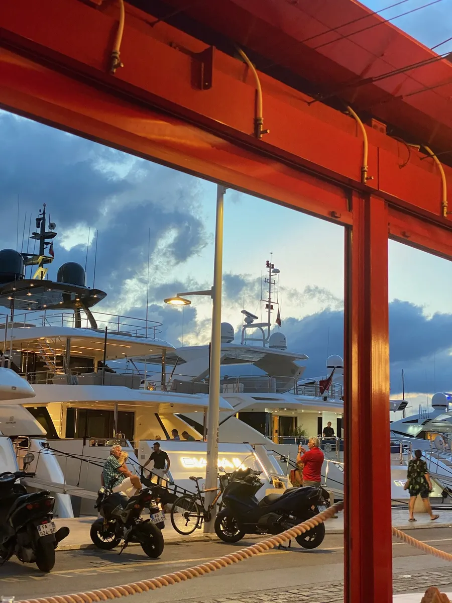 Yachts in the port seen from under a red awning
